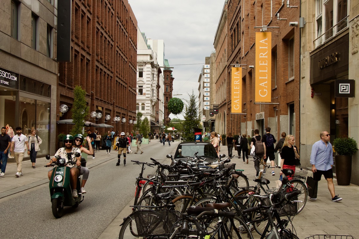 Girl on Moped waving hello in Hamburg